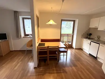 a kitchen and dining room with a table and chairs at Appartements Wiesenheim in Rasun di Sopra