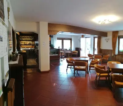 a dining room with tables and chairs in a restaurant at Albergo Belvedere in Fiera di Primiero