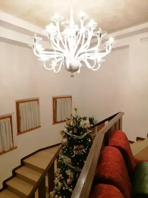 a christmas tree in a living room with a chandelier at Albergo Belvedere in Fiera di Primiero