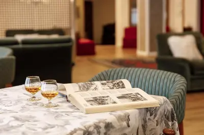 a table with a book and two glasses of wine at Albergo Belvedere in Fiera di Primiero