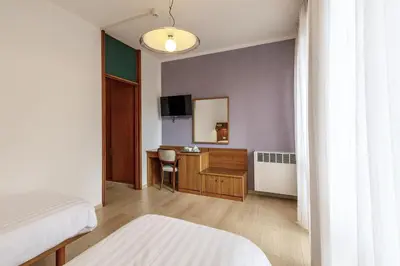 a hotel room with a bed and a desk at Albergo Belvedere in Fiera di Primiero
