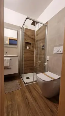 a bathroom with a toilet and a glass shower at Hotel Villa Gaia in Cortina dʼAmpezzo