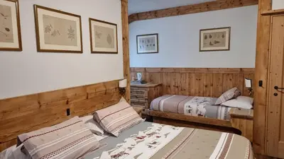 a bedroom with two beds in a room at Hotel Villa Gaia in Cortina dʼAmpezzo