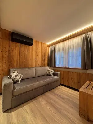 a living room with a couch and a window at Affittacamere Villa Sole in Fiera di Primiero