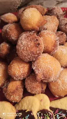 a pile of donuts with powdered sugar on them at Affittacamere Villa Sole in Fiera di Primiero