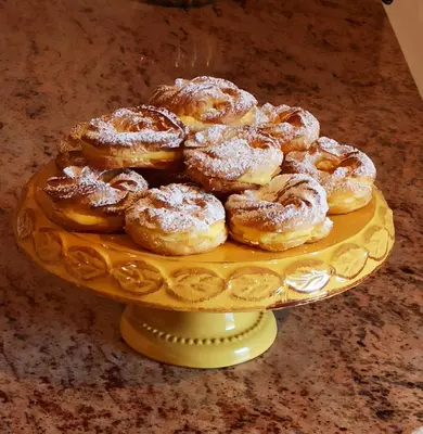 a pile of powdered donuts on a yellow plate at Affittacamere Villa Sole in Fiera di Primiero