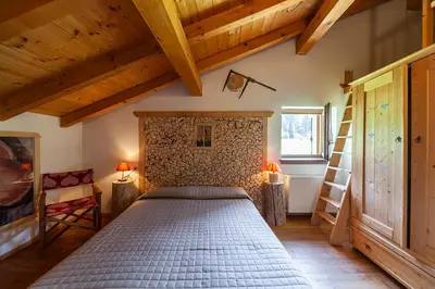 a bedroom with a bed in a room with wooden ceilings at Albergo Lozen in Canale San Bovo