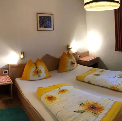 a bedroom with two beds with yellow pillows at Fless in San Martino in Badia