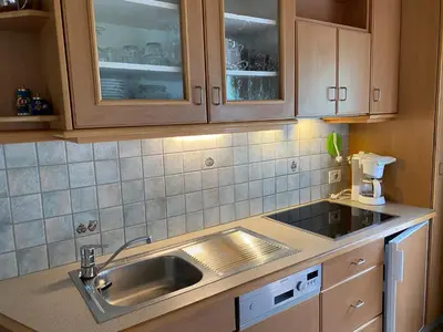 a kitchen with a sink and wooden cabinets at Chalet Romy - Ap Saslonch in Pramauron