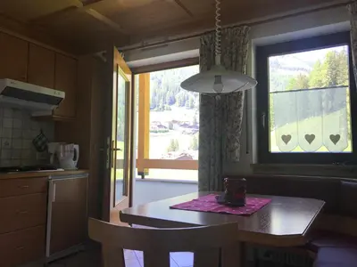 a kitchen with a table and a large window at Chalet Romy - Ap Saslonch in Pramauron