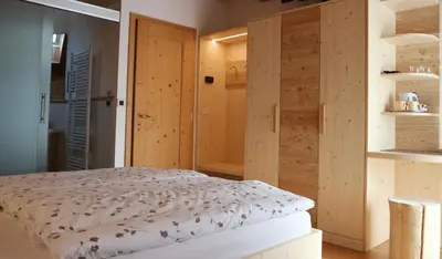a bedroom with a bed and wooden walls at B&B Casa Riz in Castello di Fiemme