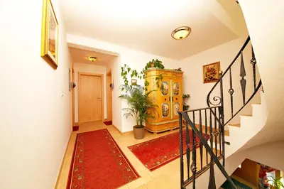 a hallway with a staircase with a red rug at Residence Tauber in Valles