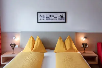 a room with two beds with yellow pillows at Residence Tauber in Valles