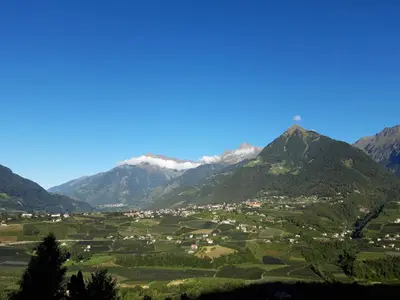 a village in a valley with mountains in the background at Appartment Maria in Schenna