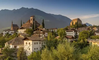 a town with buildings and a mountain in the background at Appartment Maria in Schenna