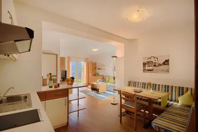 a kitchen and living room with a table and a dining room at Appartment Maria in Schenna