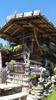 a wooden house with flowers and a staircase at Appartment Maria in Schenna