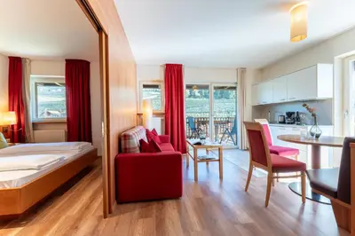 a bedroom with a bed and a living room and a kitchen at Feldhof Schenna in Schenna
