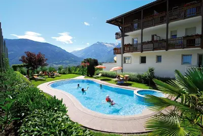 a group of people in a swimming pool next to a building at Feldhof Schenna in Schenna