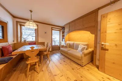 a living room with a table and a couch at Cadin Apartment in Cortina dʼAmpezzo