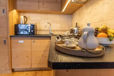 a kitchen counter with a tea kettle and a bowl of fruit at Cadin Apartment in Cortina dʼAmpezzo