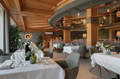a dining room with white tables and chairs at Hotel Starkenberg in Schenna