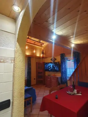 a living room with a table and a tv at casa claudio-APPARTAMENTI IN CENTRO in Campitello di Fassa