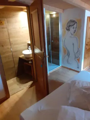 a bedroom with a bathroom with a shower and a sink at casa claudio-APPARTAMENTI IN CENTRO in Campitello di Fassa