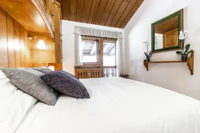a room with a bed and a mirror at Dolomiti Sweet Lodge in Cortina dʼAmpezzo