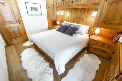 a bedroom with a bed with white sheets and pillows at Dolomiti Sweet Lodge in Cortina dʼAmpezzo