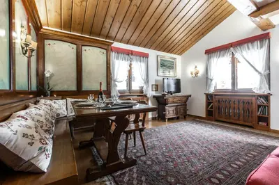 a living room with a red couch and a table at Dolomiti Sweet Lodge in Cortina dʼAmpezzo
