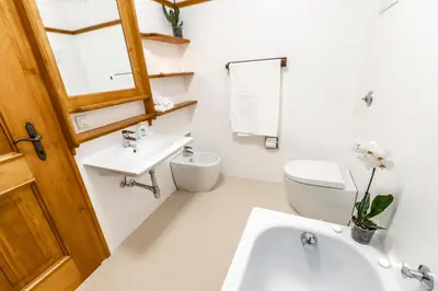 a white bathroom with a sink and a toilet at Dolomiti Sweet Lodge in Cortina dʼAmpezzo