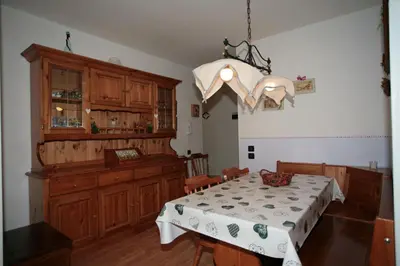 a dining room with a table and a chandelier at Residence Valfassa in Canazei