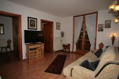 a living room with a couch and a flat screen tv at Residence Valfassa in Canazei