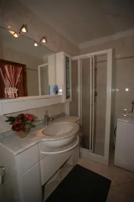a bathroom with a sink and a mirror and a shower at Residence Valfassa in Canazei
