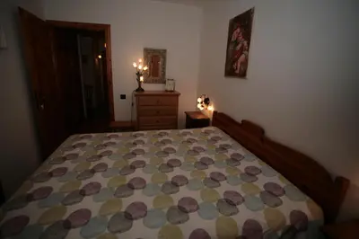 a bedroom with a bed with a quilt on it at Residence Valfassa in Canazei