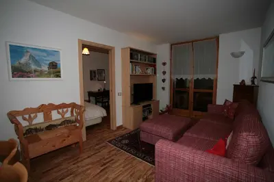 a living room with a couch and a bed at Residence Valfassa in Canazei