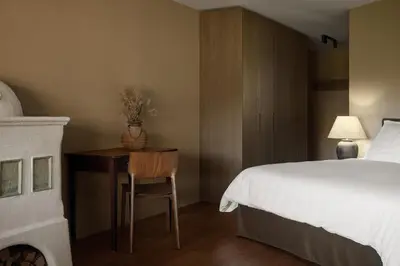 a bedroom with a bed and a desk and a bed and a bedskirts at Saltus in San Genesio Atesino