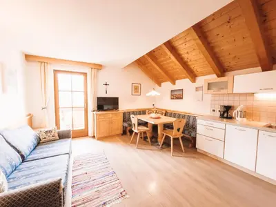 a kitchen with white cabinets and a wooden ceiling at Apartment Fedares in La Valle