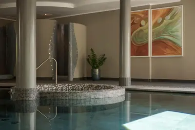 a bathroom with a tub and a swimming pool at Hotel Dorner B&B in Lagundo