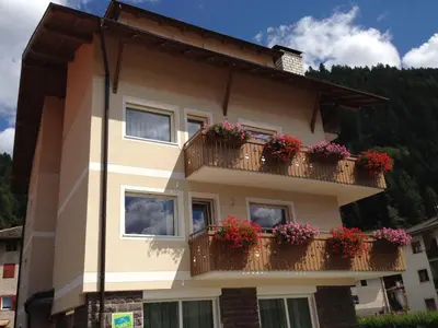 a building with flower boxes on its balconies at Appartamento Rose Di Bosco in Predazzo