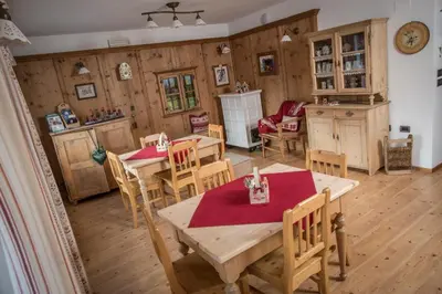 a kitchen and dining room with wooden tables and chairs at Appartamento Rose Di Bosco in Predazzo