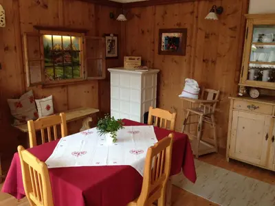 a dining room with a table and chairs and a kitchen at Appartamento Rose Di Bosco in Predazzo