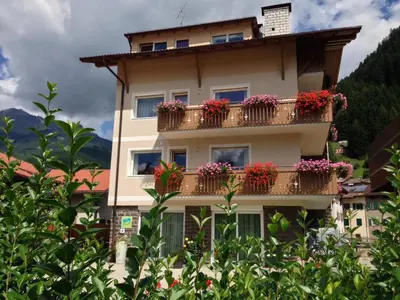 a building with flower boxes on the balconies at Appartamento Rose Di Bosco in Predazzo