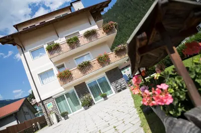 a building with potted plants on the balconies at Appartamento Rose Di Bosco in Predazzo