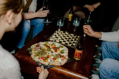 a group of people sitting around a table with a pizza at Nancy's Holiday Homes Dolomites in Rasùn di Sotto