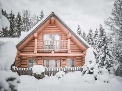 a log cabin with a balcony in the snow at Nancy's Holiday Homes Dolomites in Rasùn di Sotto
