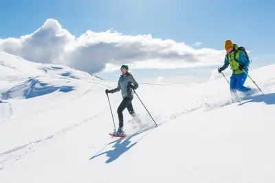 two people are skiing down a snow covered slope at Ciasa Rosra in La Villa