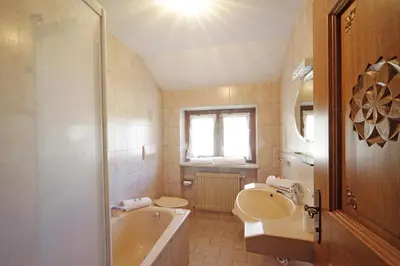 a bathroom with a sink and a tub and a toilet at Ciasa Rosra in La Villa