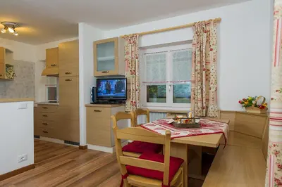 a kitchen and dining room with a table and chairs at Majon Vajolet - Apartments Luisa in Vigo di Fassa